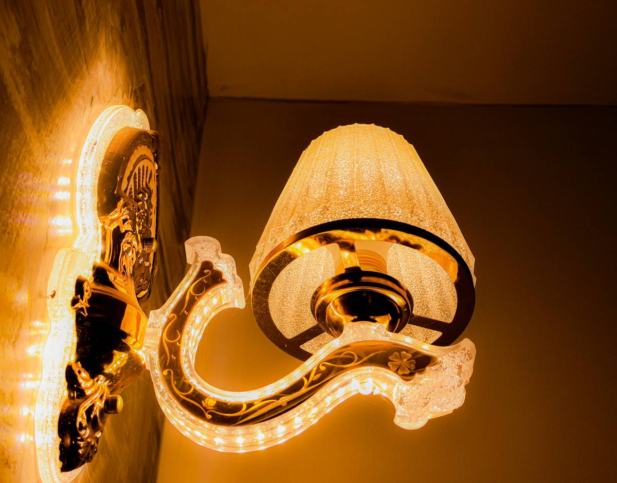 Diagram showing how interior wall sconce light fixtures bounce light vertically to create depth and reduce facial shadows