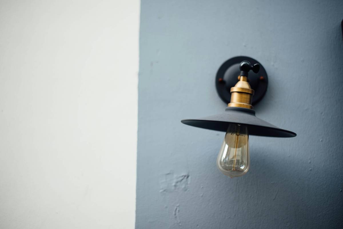Infographic comparing hardwired, plug-in, and battery-powered wall sconces showing wiring requirements, installation difficulty, and best use cases