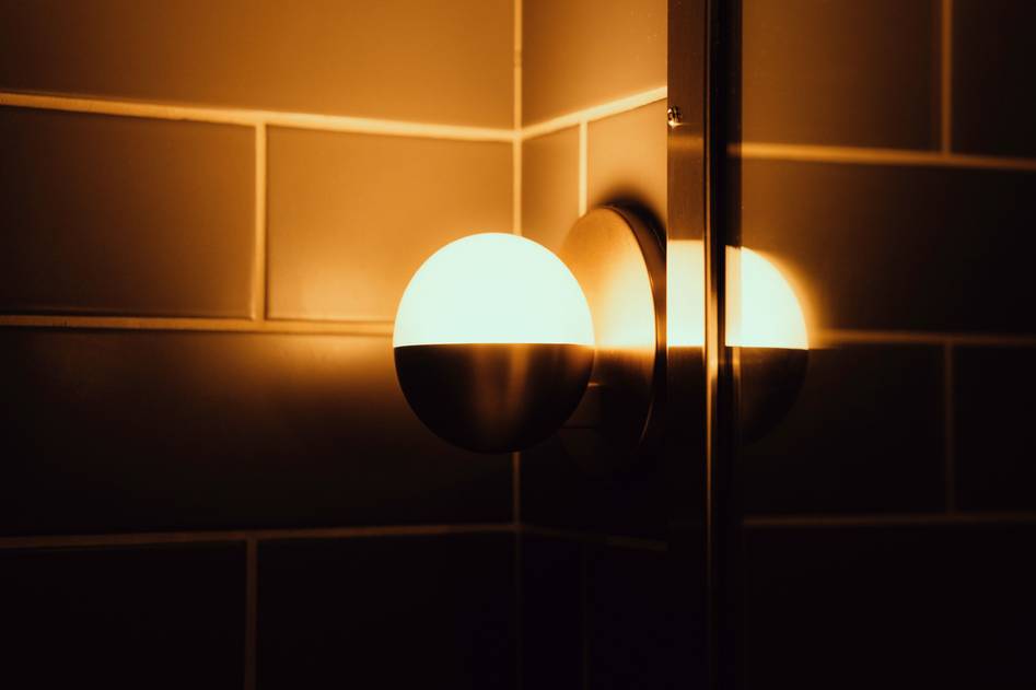 Modern wall sconces casting warm light on textured wall