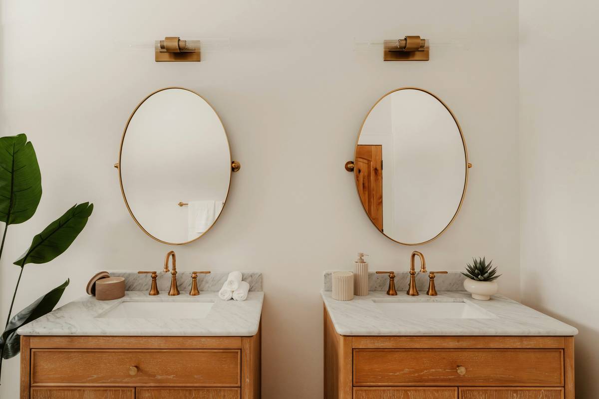 Side-by-side comparison: overhead-only lighting casting harsh facial shadows vs. wall sconces providing even, shadow-free illumination