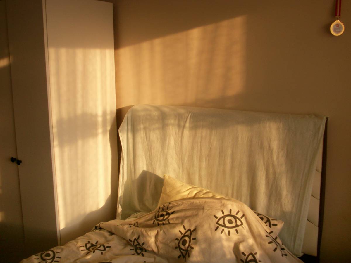 Diagram showing ideal wall sconce placement at 60-66 inches with downward light angle reducing glare and supporting melatonin production