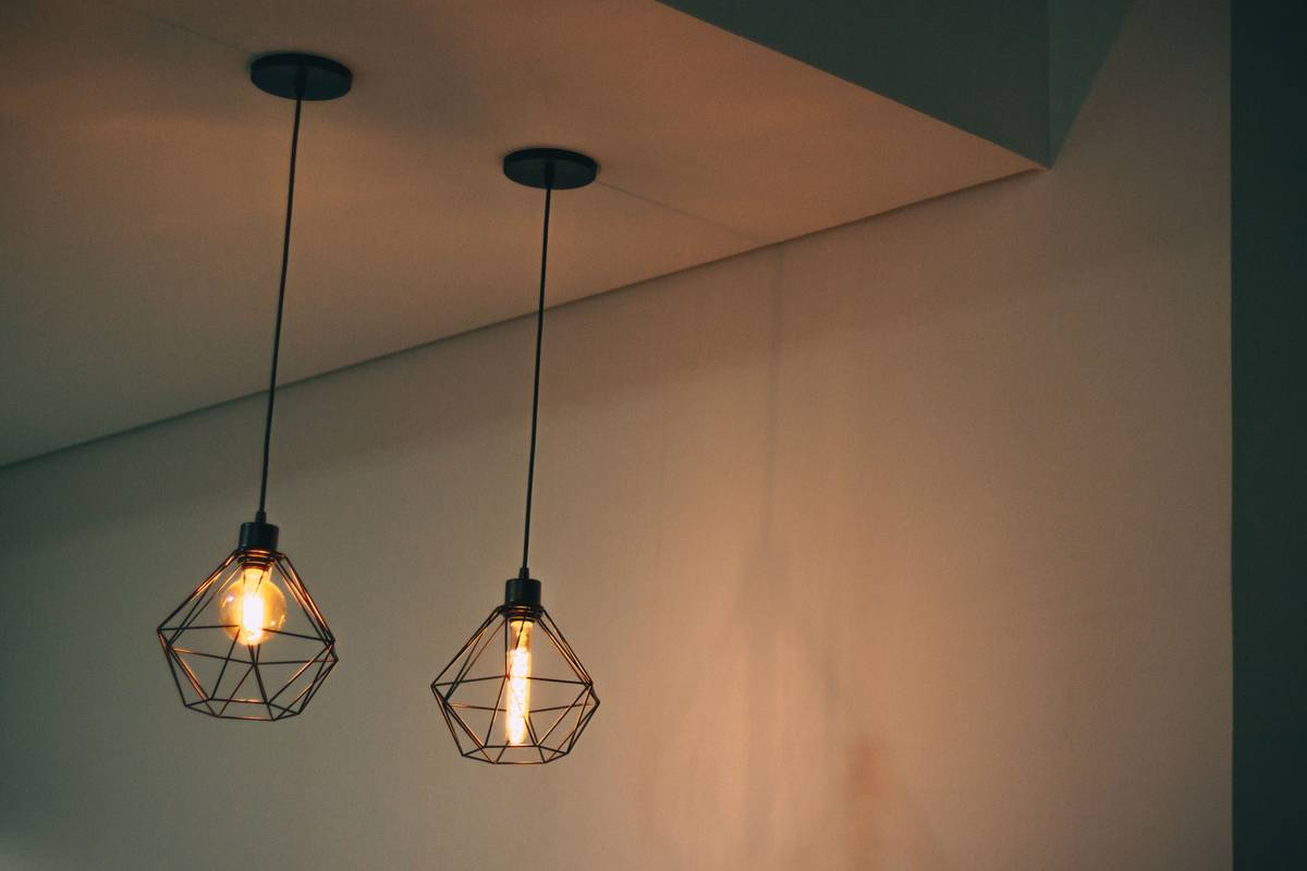 Diagram showing layered lighting: ambient ceiling light, task desk lamp, accent wall sconce