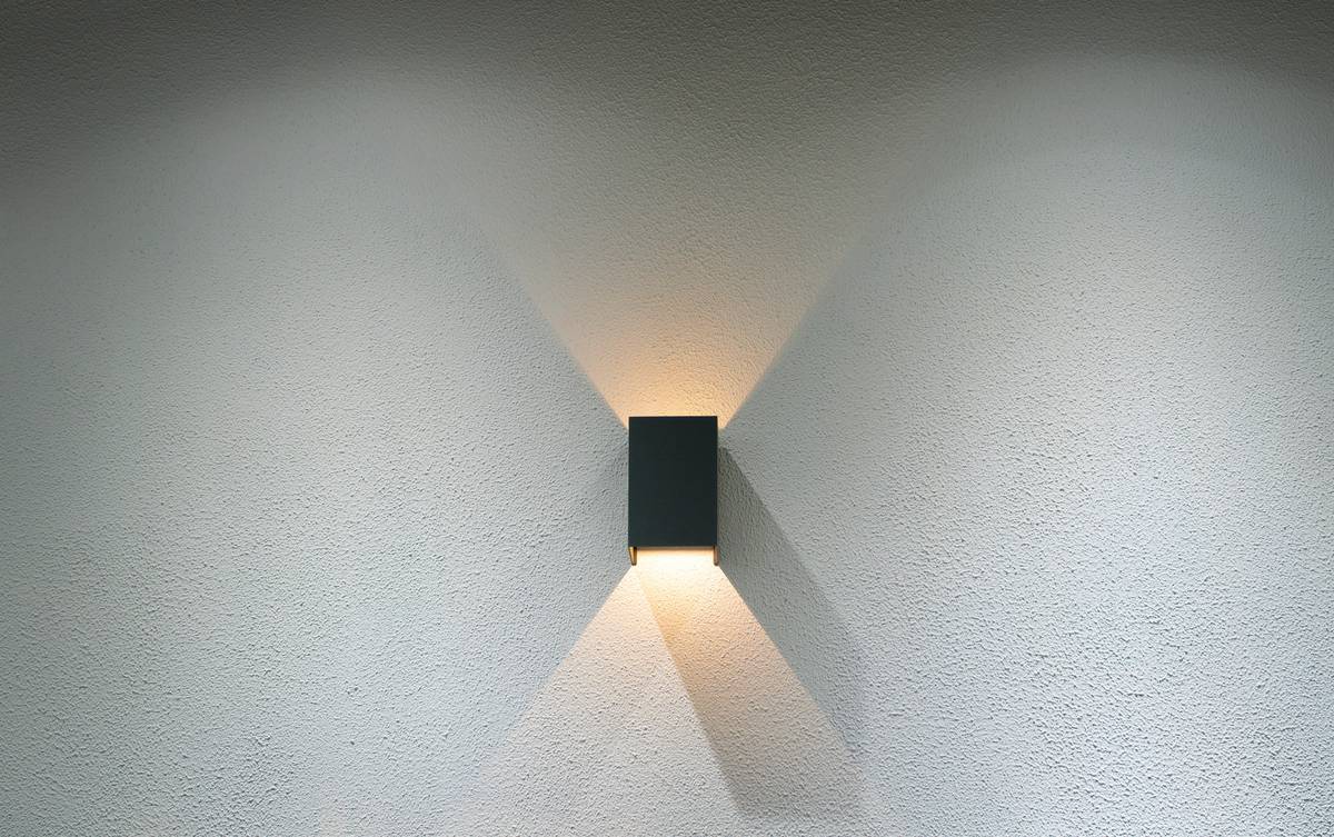 Hardwired wall mounted sconce lighting fixtures installed symmetrically beside a hallway mirror