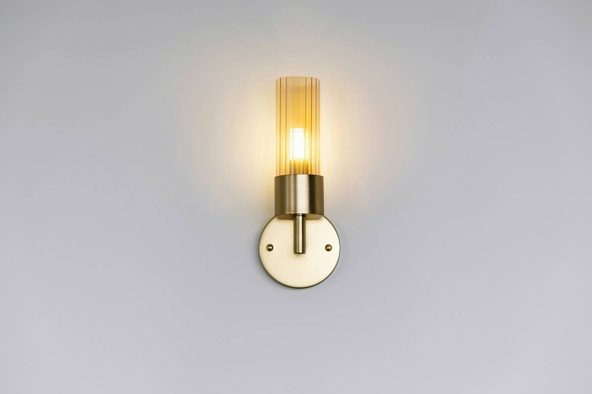 Modern wall mounted sconce lighting fixtures casting upward ambient glow in minimalist living room